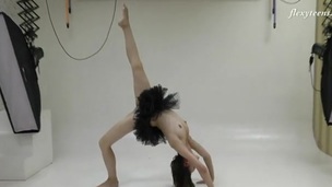 Ballerina in a pitch-black dress does relation splits
